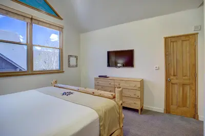 a bedroom with a bed and a tv and a window at Black Bear 8079 in Keystone