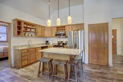 a kitchen with wooden cabinets and a island with bar stools at Black Bear 8079 in Keystone