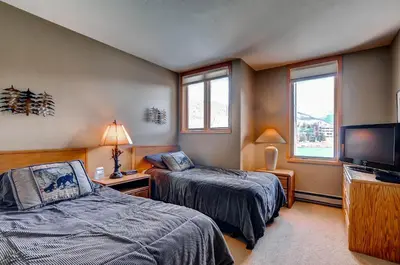 a bedroom with two beds and a flat screen tv at Argentine 1525 in Keystone