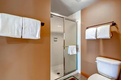 a bathroom with a shower and a toilet and towels at Argentine 1525 in Keystone