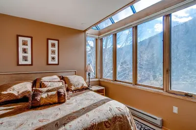 a bedroom with a bed and a bunch of windows at Argentine 1525 in Keystone