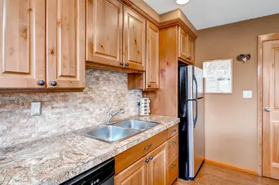a kitchen with wooden cabinets and a sink and a refrigerator at Argentine 1525 in Keystone