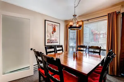 a dining room with a wooden table and chairs at Flying Dutchman 1124 in Keystone