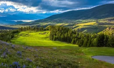 a lush green golf course with trees and a river at Flying Dutchman 1124 in Keystone