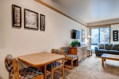 a living room with a table and a couch at Slopeside 2741 in Keystone