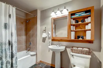 a bathroom with a sink and a toilet and a mirror at Red Hawk Lodge 2207 in Keystone
