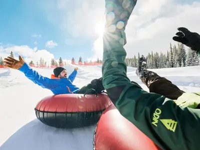 a group of people laying in the snow on a sled at Red Hawk Lodge 2207 in Keystone