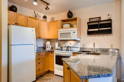 a kitchen with white appliances and wooden cabinets at Silver Mill 8308 in Keystone