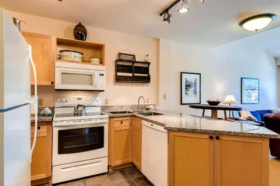 a kitchen with white appliances and a living room at Silver Mill 8308 in Keystone