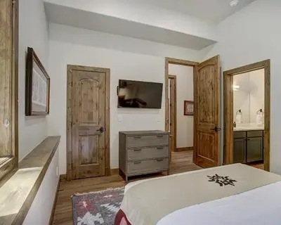 a bedroom with a bed and a bathroom with a sink at Settlers Creek 6466 in Keystone