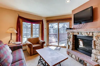 a living room with a fireplace and a tv at Expedition Station 8613 in Keystone