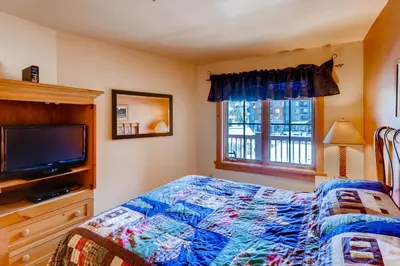a bedroom with a bed and a flat screen tv at Expedition Station 8613 in Keystone