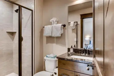 a bathroom with a toilet and a sink and a shower at River Run Townhome RR37 in Keystone