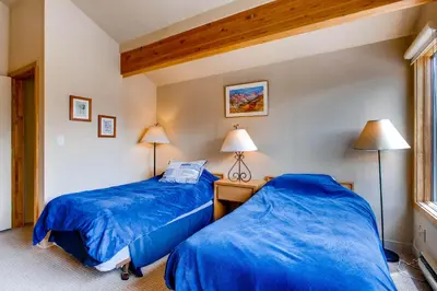 two beds in a room with blue sheets at Willows 1716 in Keystone