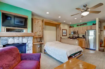 a living room with a bed and a fireplace at Buffalo Lodge 8385 in Keystone