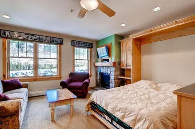 a bedroom with a bed and a couch and a tv at Buffalo Lodge 8385 in Keystone