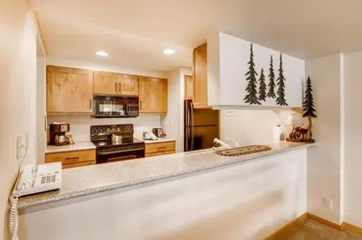 a kitchen with wooden cabinets and a white refrigerator at Sts, Johns 2541 in Keystone
