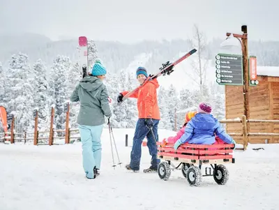 a group of people pulling a person in a sled in the snow at Lone Eagle 3031 in Keystone