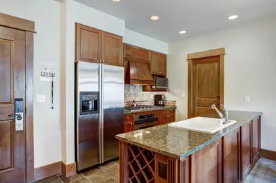 a kitchen with wooden cabinets and a stainless steel refrigerator at Lone Eagle 3031 in Keystone