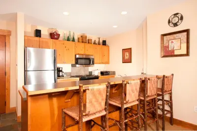 a kitchen with a counter and a refrigerator at Springs 8848 in Keystone
