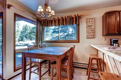 a dining room with a table and chairs and a window at Flying Dutchman 1210 in Keystone
