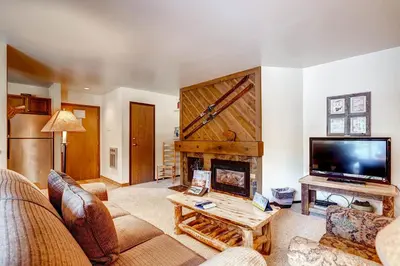 a living room with a fireplace and a flat screen tv at Flying Dutchman 1210 in Keystone
