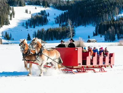 a group of people riding in a horse drawn sleigh in the snow at Gateway 5070 in Keystone