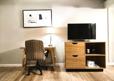 a room with a desk with a chair and a television at Days Inn by Wyndham Denver Downtown in Denver