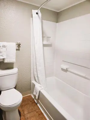 a bathroom with a toilet and a bath tub with a toilet at Days Inn by Wyndham Denver Downtown in Denver