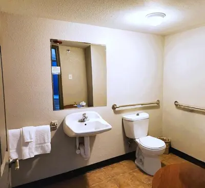 a bathroom with a sink and a toilet and a mirror at Days Inn by Wyndham Denver Downtown in Denver