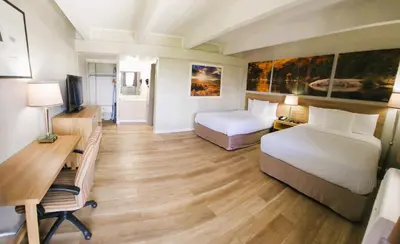 a hotel room with two beds and a desk at Days Inn by Wyndham Denver Downtown in Denver