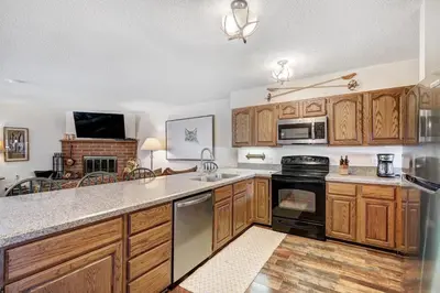 a kitchen with wooden cabinets and a stove top oven at Lagoon 762B Townhouse in Frisco