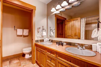 a bathroom with two sinks and a toilet at Springs 8831 in Keystone