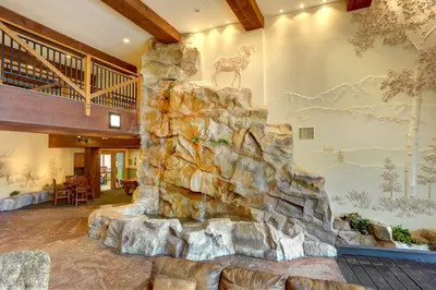 a large stone fireplace in a room with a rock wall at Springs 8831 in Keystone