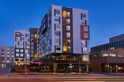 a tall building on a city street at night at MOXY Denver Cherry Creek in Denver
