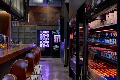 a bar with brown chairs and a counter with drinks at MOXY Denver Cherry Creek in Denver