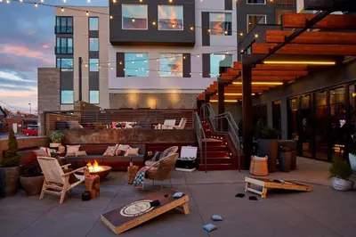 a rooftop patio with a fire pit and a building at MOXY Denver Cherry Creek in Denver