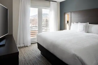 a hotel room with a bed and a large window at Residence Inn by Marriott Boulder Canyon Boulevard in Boulder