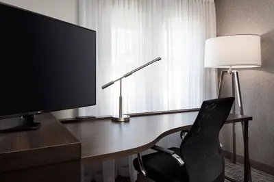 a desk with a television and a chair next to a window at Residence Inn by Marriott Boulder Canyon Boulevard in Boulder