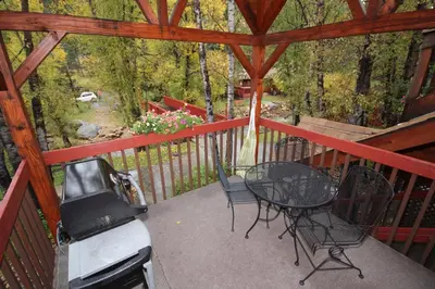a screened in porch with a table and chairs at Streamside on Fall River in Estes Park