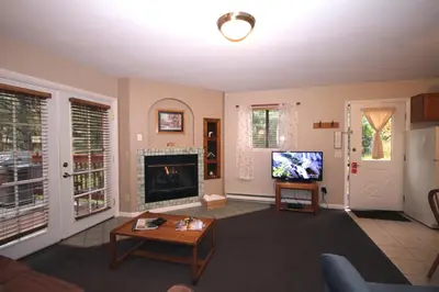 a living room with a fireplace and a tv at Streamside on Fall River in Estes Park