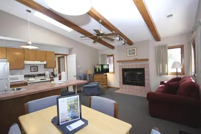 a kitchen and living room with a laptop on a table at Streamside on Fall River in Estes Park