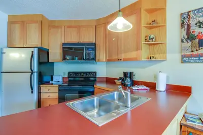 a kitchen with a sink and a refrigerator at Iron Horse Studio in Winter Park