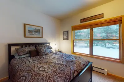 a bedroom with a large bed and a window at Snake River Village in Keystone