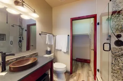 a bathroom with a wooden sink and a toilet at Snake River Village in Keystone
