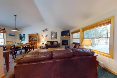 a living room with a couch and a dining room at Snake River Village in Keystone