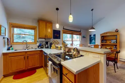 a kitchen with wooden cabinets and a stove top oven at Snake River Village in Keystone