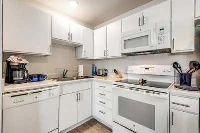 a white kitchen with white cabinets and appliances at Parks Residential Denver in Centennial