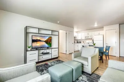 a living room with a tv and a couch and chairs at Parks Residential Denver in Centennial