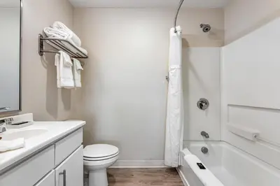 a white bathroom with a toilet and a bath tub at Parks Residential Denver in Centennial